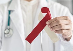 Doctor holding an oral cancer ribbon