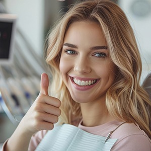 Happy dental patient making thumbs-up gesture