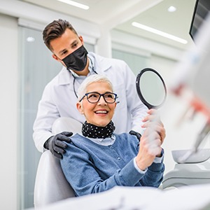 A cheerful older admiring her implant dentures