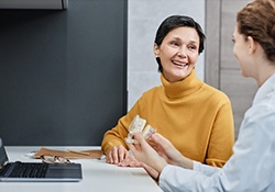 A woman talking to her dentist about implant dentures